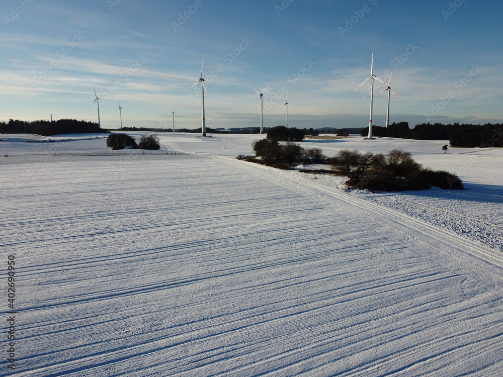 Aerial view of wind turbines on a snowy field in Germany. Aerial view of wind turbines on a snowy field in Germany.