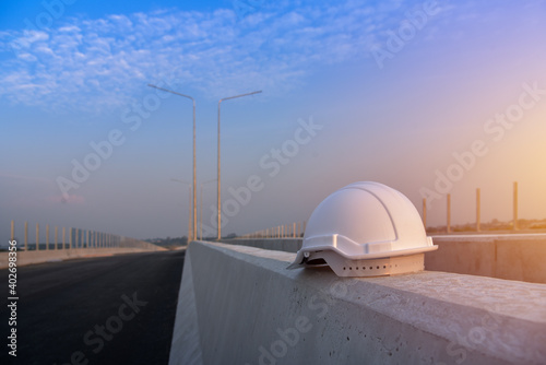 Safety hard helmet on concrete in construction site fore build a bridge and sunset by worker at site, fore safety concept.