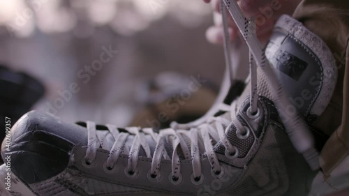 Lacking up ice skates. Winter sports and hockey skates. Getting ready to get on the ice. Snow and winter wonderland
