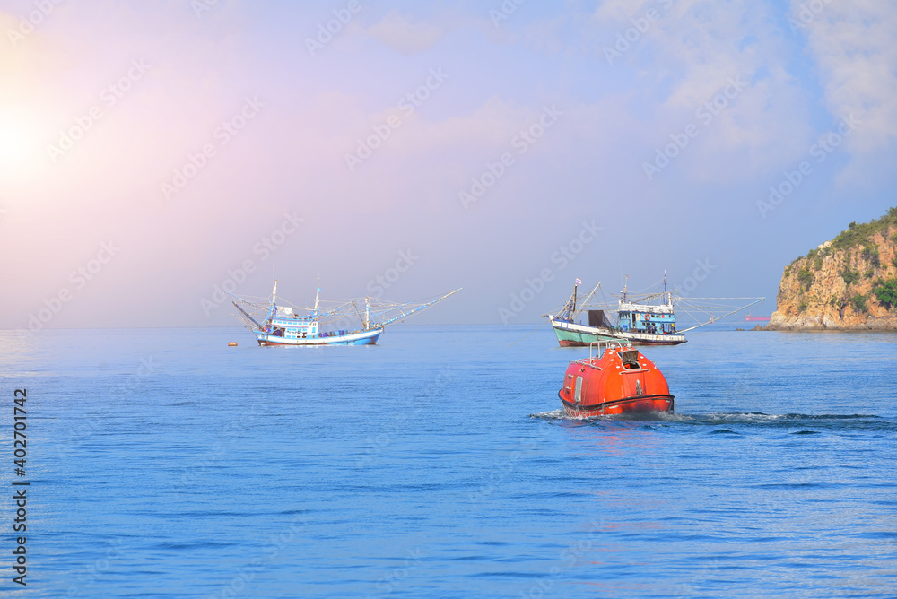 Lifeboat or rescue boat Testing quality checking in the sea offshore oil and gas installations during inspection and maintenance by fhishig boat mooring alongside in the sea. Lifeboat or rescue boat Testing quality checking in the sea offshore oil and gas installations during inspection and maintenance by fhishig boat mooring alongside in the sea.