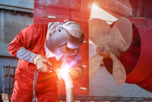 Konstfotografi Industry building ship,Welding worker with spark weld factory at shipbuilding and ship Repairing industrials, wear equipment protective for safety on propeller with rudder of cargo ship background