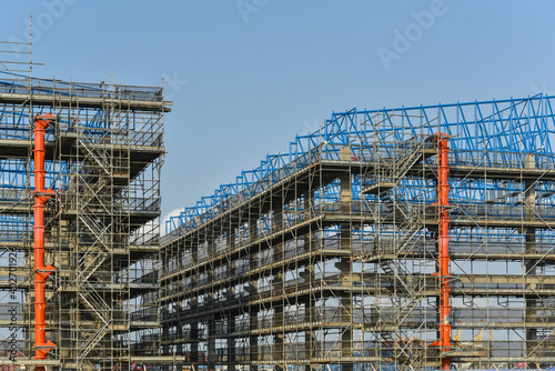 Steel structure factory in construction site, with structure steel and scafolding installed for worker on high for safety concept photo