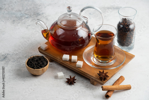 A glass cup of tea with sugar and star anise