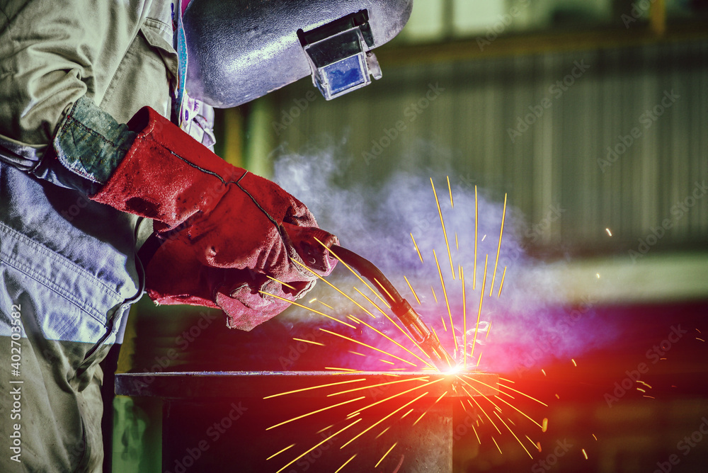 Welder industrial in factory welding process Mig, with light spark from working light, equipment protective PPE for safety. Welder industrial in factory welding process Mig, with light spark from working light, equipment protective PPE for safety.
