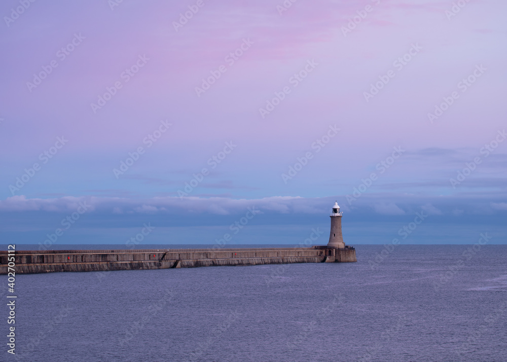 Pink evening light over the pier and lighthouse at the mouth of the River Tyne, North East England, UK. Pink evening light over the pier and lighthouse at the mouth of the River Tyne, North East England, UK.