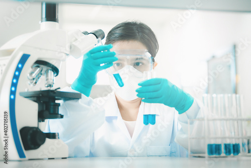 Doctor or scientist in laboratory holding liquid vaccines in medical research lab or science laboratory