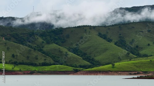 Clouds evaporating on the top of the mountain during the afternoon, mountain next to a lake. Time lapse video. Landscape of the Lago de Furnas lake, at Capitólio - Minas Gerais, Brazil. photo