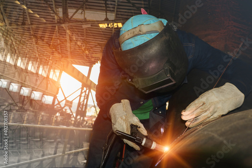 worker Tig welding at Industrial business concept with technician focus on welding process with equipment protective mask welder, leather gloves, PPE at construction site