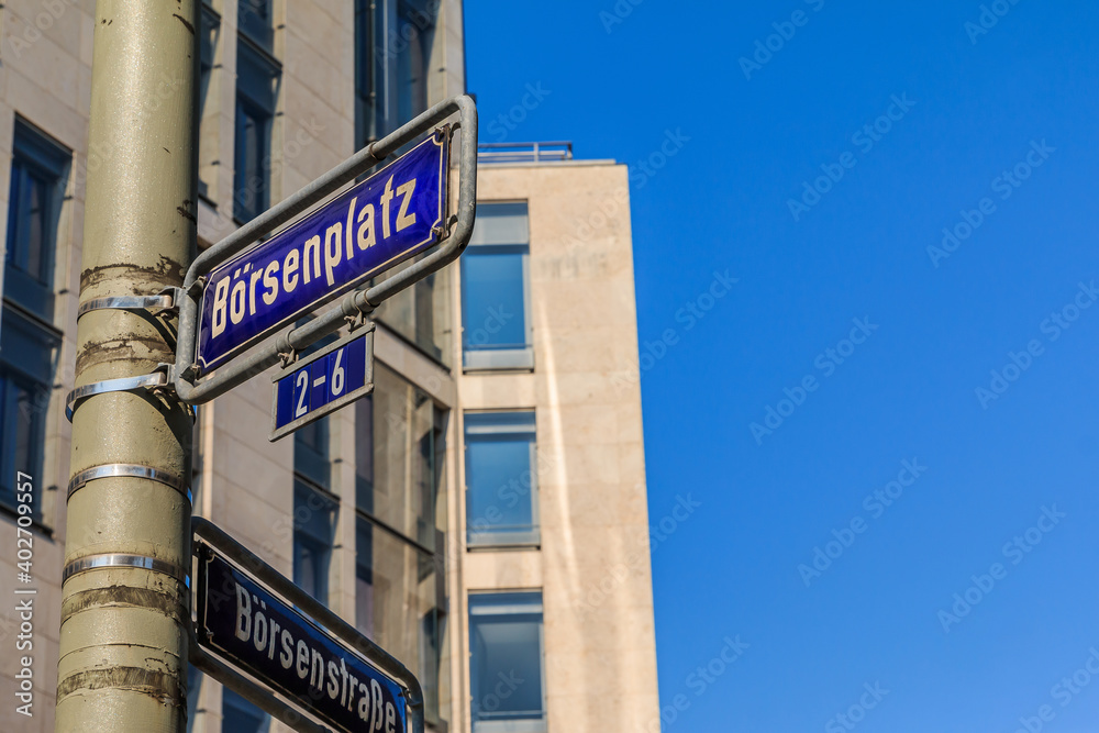 blue traffic sign stock exchange place and stock exchange street on a gray lamppost with fixings. House with window facade in the background with blue sky. blue traffic sign stock exchange place and stock exchange street on a gray lamppost with fixings. House with window facade in the background with blue sky.