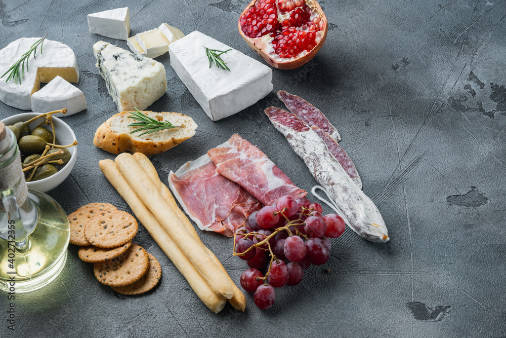 Spanish snacks, meat cheese, herbs, on gray background  with copy space for text