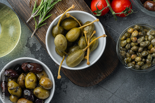 Mediterranean olives and capers, on gray background, top view