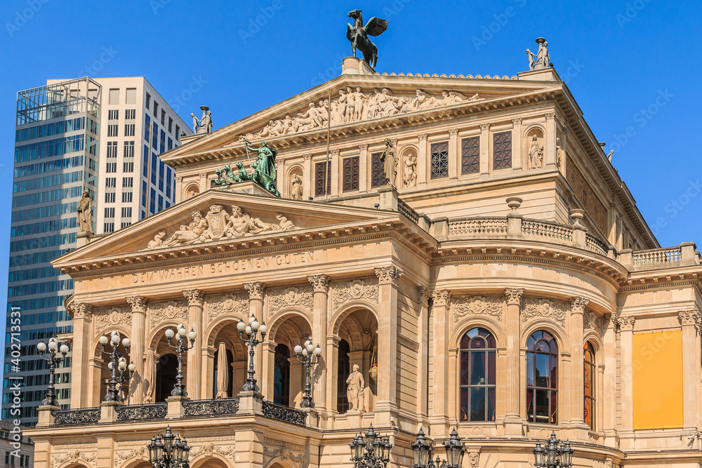 Historic building of the old opera house in Frankfurt in springtime with sunshine. Public square in the center of the city with commercial and office buildings in the background