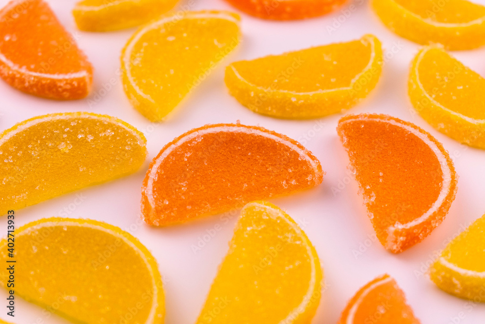 
Marmalade candies in the form of slices of orange and lemon on a white plate. Background from sweets.