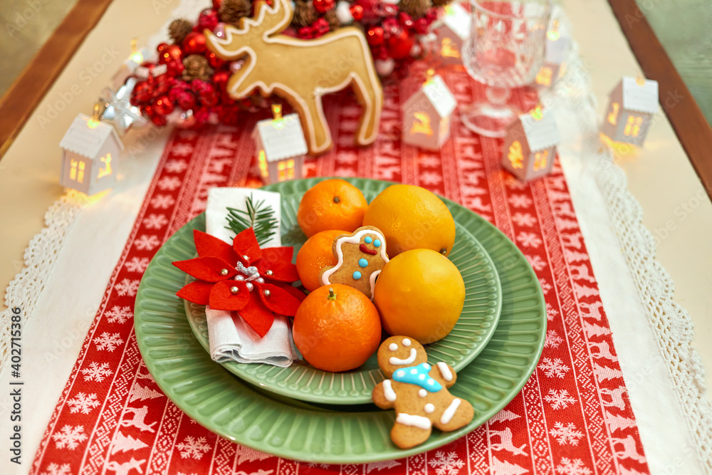 Christmas cookies with festive decor, Christmas tree, tangerines, beautiful dishes, glasses. Winter Holidays.
