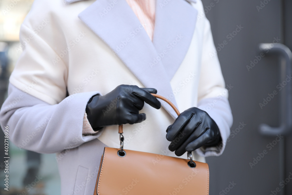 Woman with leather gloves and stylish bag outdoors, closeup