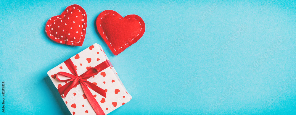 Holiday composition of gift boxes and red textile hearts on colorful background with empty space for your design. Top view of Valentine's Day concept Holiday composition of gift boxes and red textile hearts on colorful background with empty space for your design. Top view of Valentine's Day concept