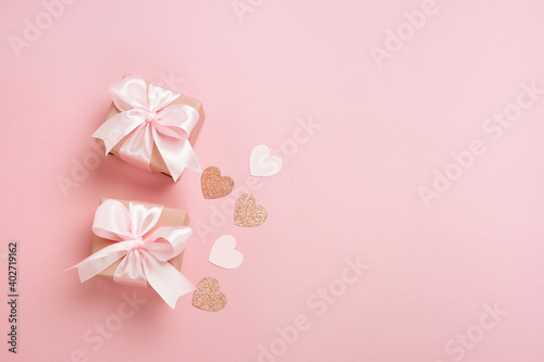 Gift boxes with pink ribbon and hearts on pastel pink background. Valentines day composition with free space. Top view, flat lay. © kaloriya