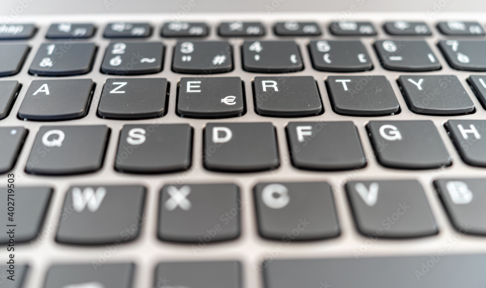 close up of computer keyboard with dark touches and silver computer close up of computer keyboard with dark touches and silver computer