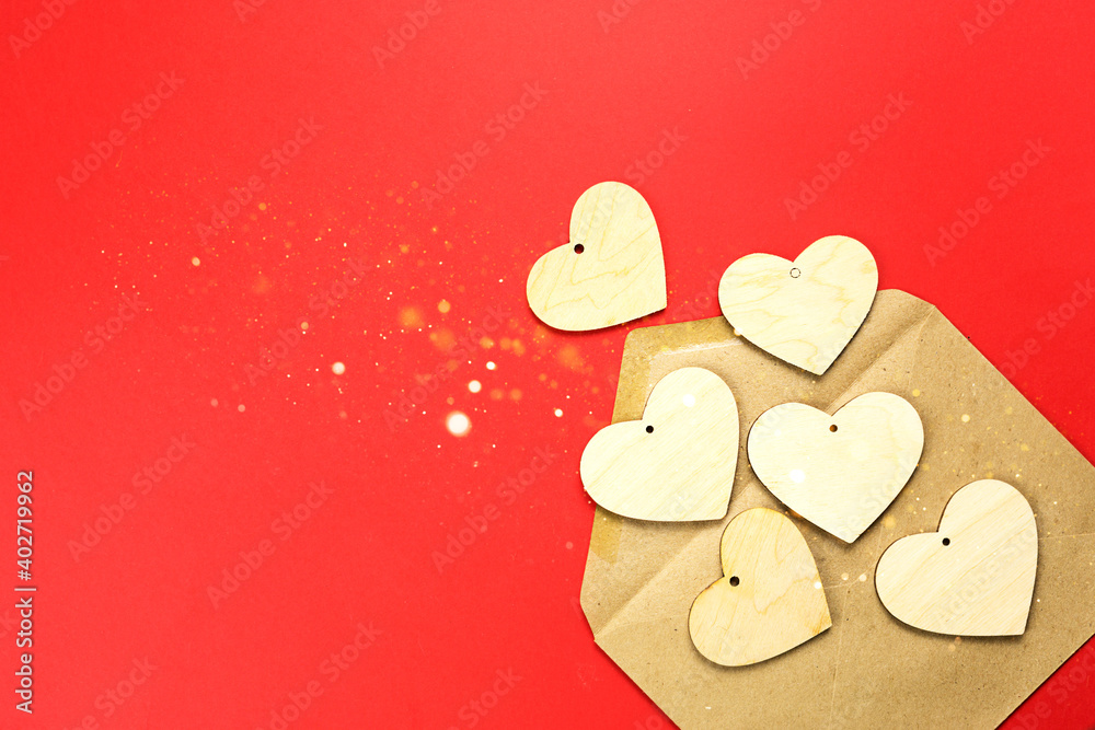 Obraz premium Wooden hearts spill out of an open envelope on a red background. Valentine's Day, love letter, declaration of love, acquaintance. Copy space, mock up