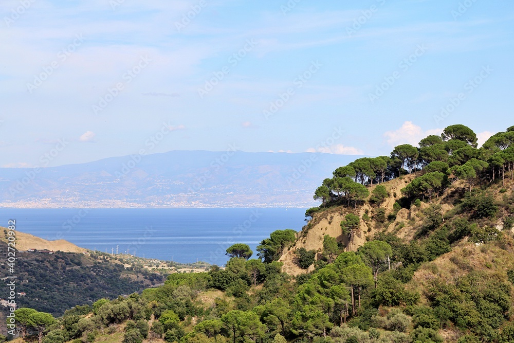 view of the mountains, hills covered with trees, pines, in the background the sea and a view of continental Italy