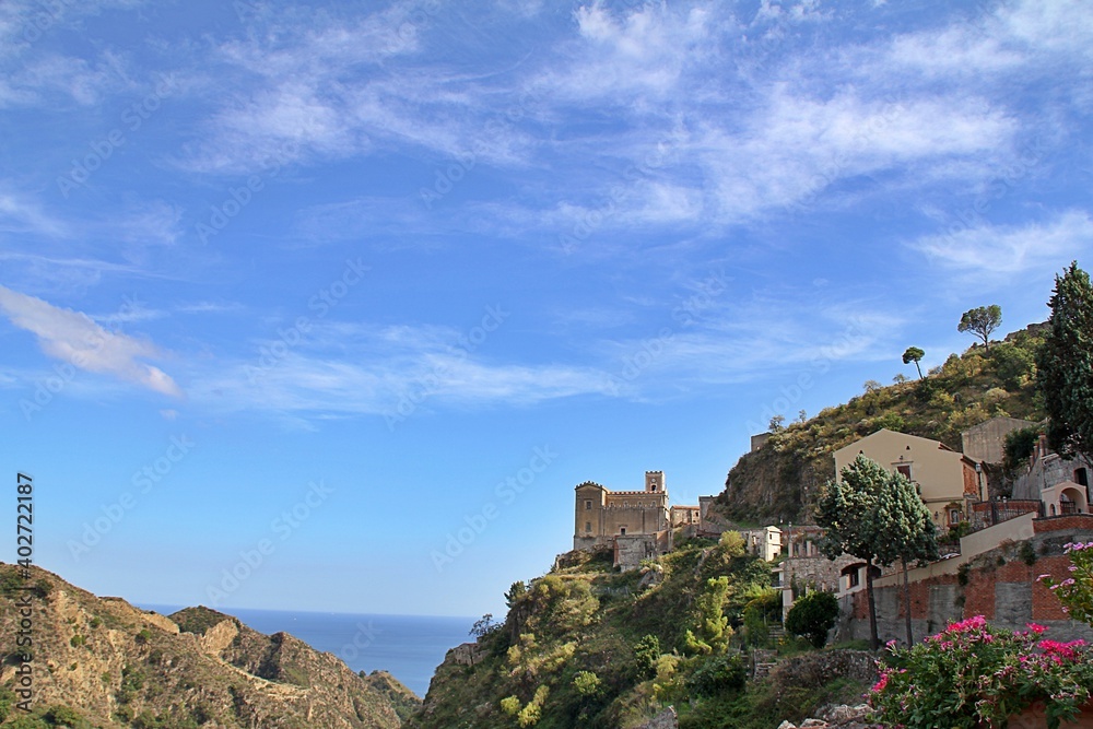 mountains, hills in Sicily, a small town of Savoca, houses and a church on a hill, a view of the sea in the distance