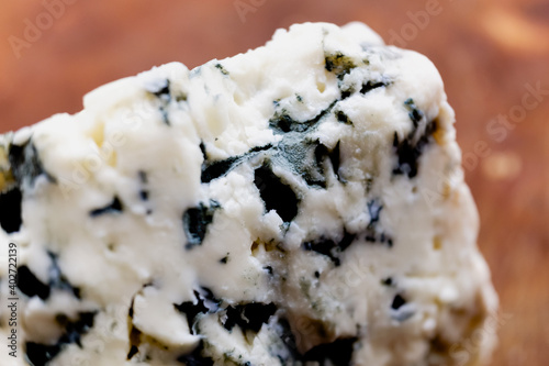 Macro close-up of a French blue cheese roquefort, tangy, crumbly and slightly moist, with distinctive veins of blue mold. photo