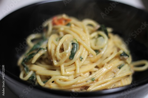 Creamy White Spaghetti Dish With Veggies in Black Bowl