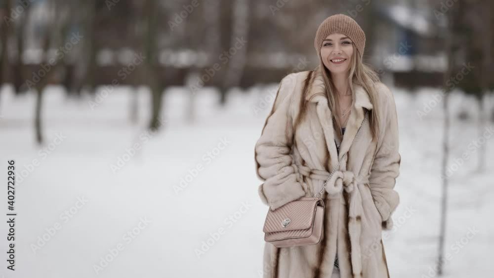 cheerful young woman is walking alone in park at winter day, medium portrait cheerful young woman is walking alone in park at winter day, medium portrait