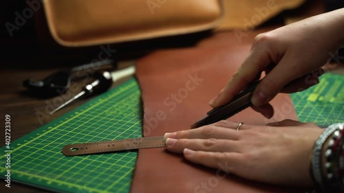 Wallpaper Mural woman uses tools for leather processing in a craft workshop Torontodigital.ca