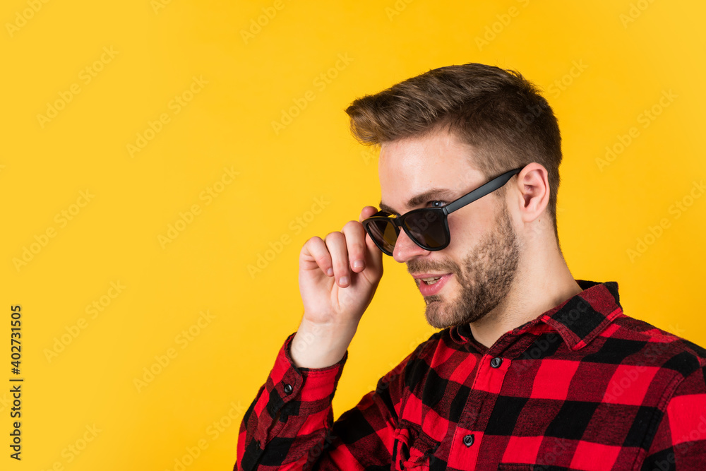 Obraz premium In traditional style. happy guy smiling. portrait of fashionable handsome man in shirt. business classic mens shirts with checkered print. confident man standing in shirt and glasses. copy space