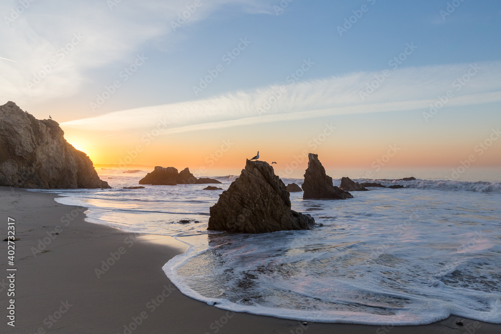 white foamy waves on rocky Malibu Beach in California at sunrise