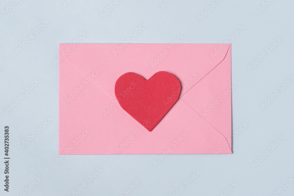 Pink envelope with red heart for valentine day on light blue background