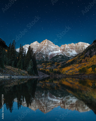Maroon Bells at night with stars and reflections.