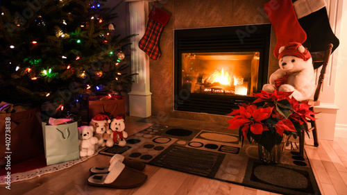 Christmas tree and living room by the fire place mantel. Cozy warm fireplace and holiday atmosphere background. stockings under the hearth and gifts by the tree