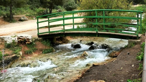 Metal green bridge at small stream in the mountains 4K photo