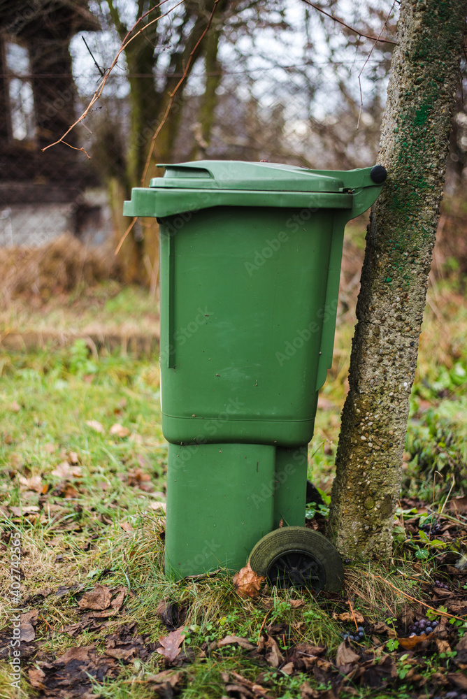 Fototapeta premium green waste bin in the garden