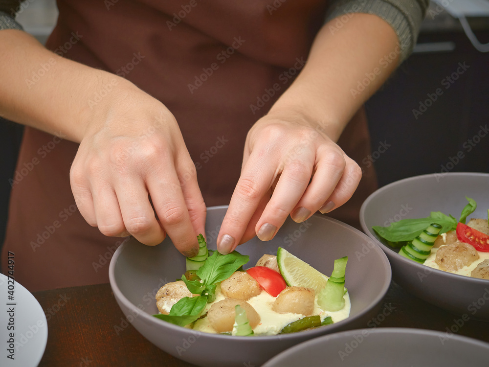 women's hands puts the food ingredients to a plate. close up.