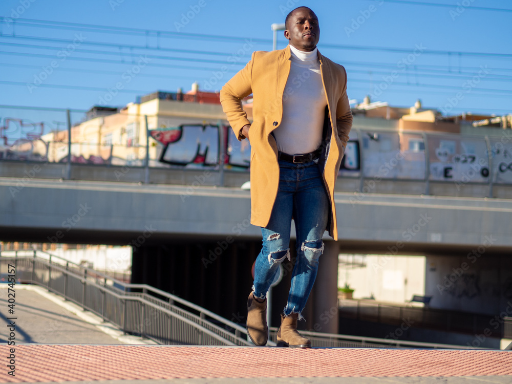 Hombre negro elegante subiendo las escaleras del metro