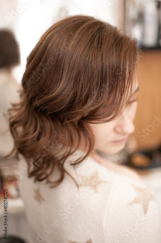 Brown-haired girl in profile with wavy hair