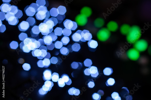 Defocused christmas decoration garland lights in bokeh. Blurred white and green  lights.