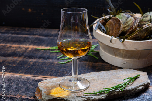 Fototapeta Naklejka Na Ścianę i Meble -  Food and drink pairing, fresh raw European flat oyster grown in Brittany in Belon river, France and scotch single malt whisky from Islay island, Scotland