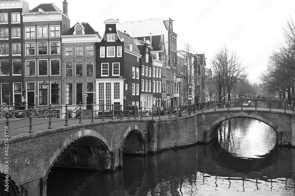 Fototapeta premium Street View Amsterdam Canal with Houses and Bridges in Black and White