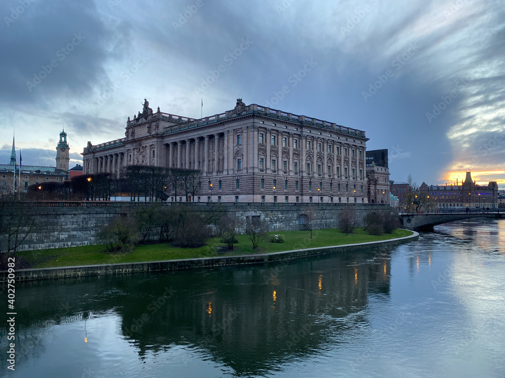 Swedish parliament in sunset surrounded with water in grey afternoon