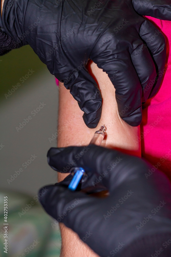 Covid-19: Nurse's hand with black people injects a vaccine against Covid-19 (SARS-COV-2) into the arm of a child.