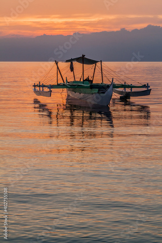 Sunset view of a bangka double-outrigger boat on Siquijor island, Philippines.