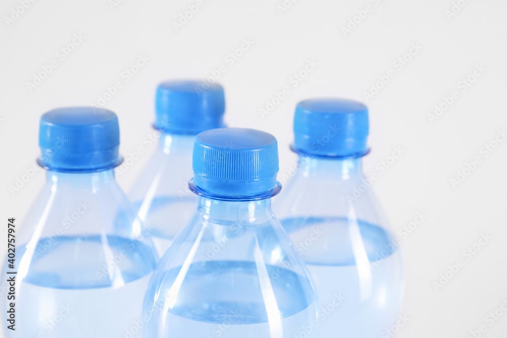 Plastic bottles with pure water on white background, closeup