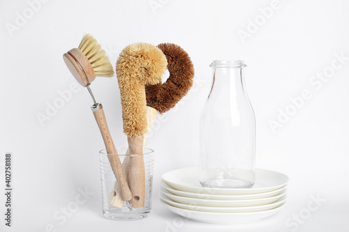 Cleaning brushes for dish washing, bottle and plates on white background