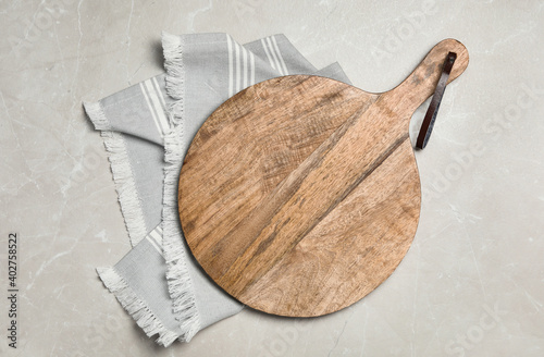 Wooden board and napkin on grey table, top view. Cooking utensil