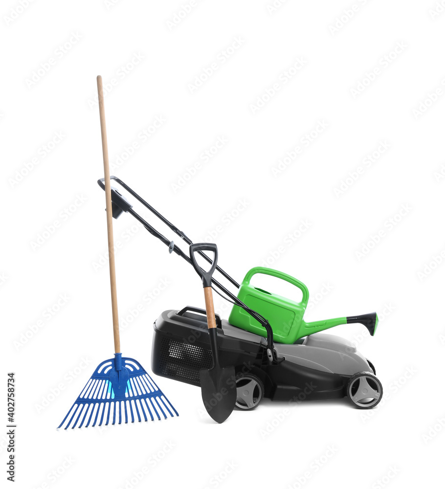 Modern electric grass cutter and gardening tools on white background Modern electric grass cutter and gardening tools on white background