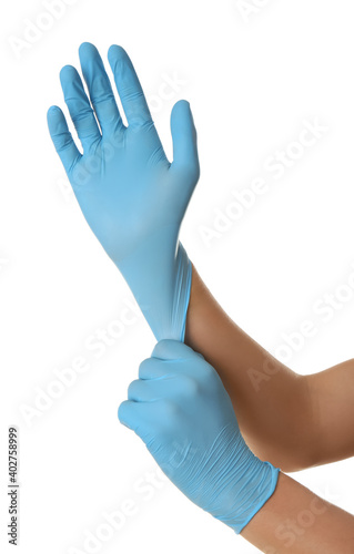 Person putting on blue latex gloves against white background, closeup © New Africa